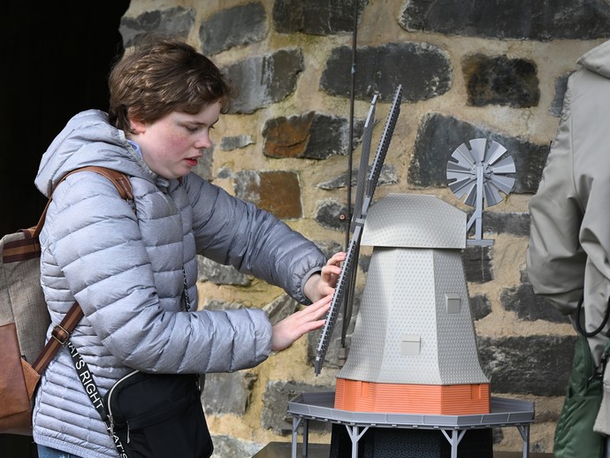 Eine Frau ertastet ein Windmühlenmodell. Eine Frau ertastet ein Windmühlenmodell.