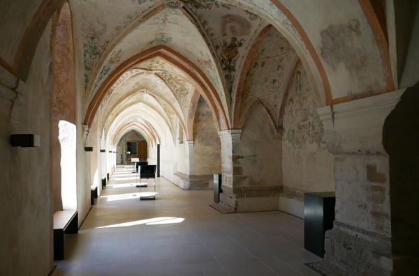 Innenraum einer historischen Kirche mit gotischen Gewölben und Bänken