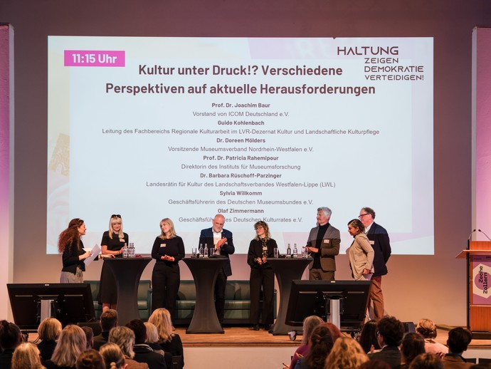 Alle Kooperationspartner:innen auf dem Eröffnungspanel mit dem Titel "Kultur unter Druck!? Verschiedene Perspektiven auf aktuelle Herausforderungen" (vergrößerte Bildansicht wird geöffnet)