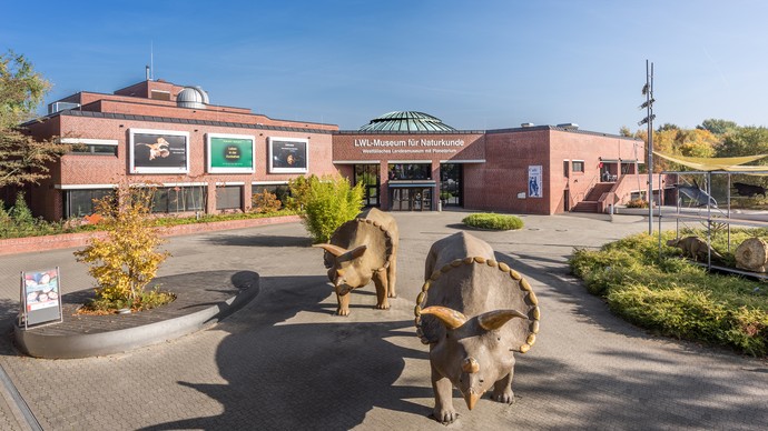 Lebensgroße Dinosaurierfiguren vor dem Eingang des LWL-Museums für Naturkunde.