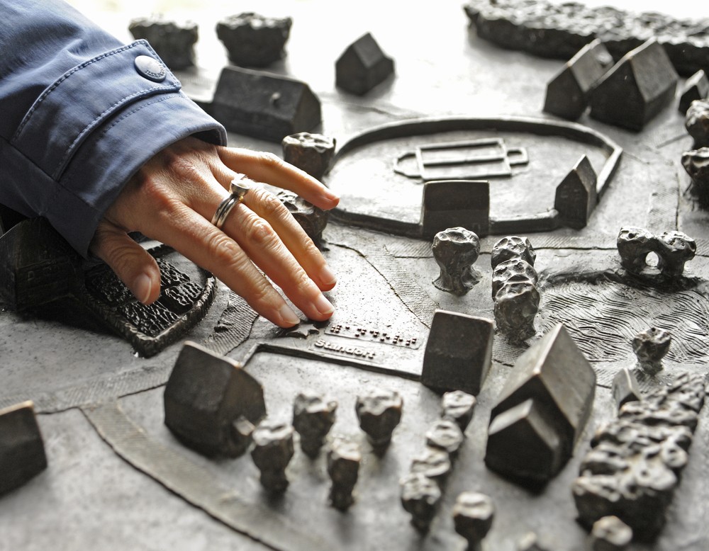 Eine Hand tastet ein Modell des Paderborner Dorfs im LWL-Freilichtmuseum Detmold ab.