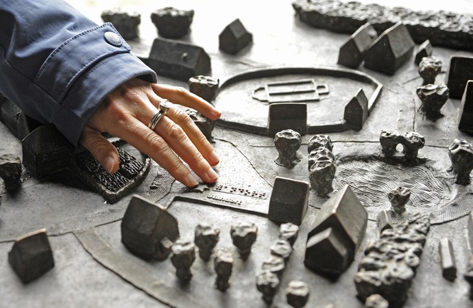 Eine Hand tastet ein Modell des Paderborner Dorfs im LWL-Freilichtmuseum Detmold ab.