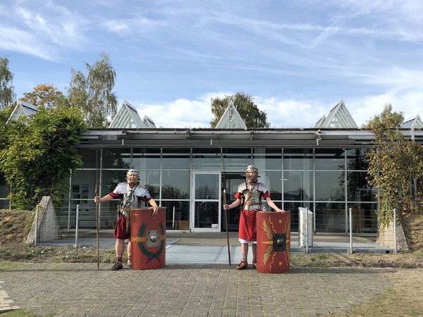 Zwei Personen, die als römische Legionäre verkleidet sind, bewachen den Eingang des LWL-Römermuseums.